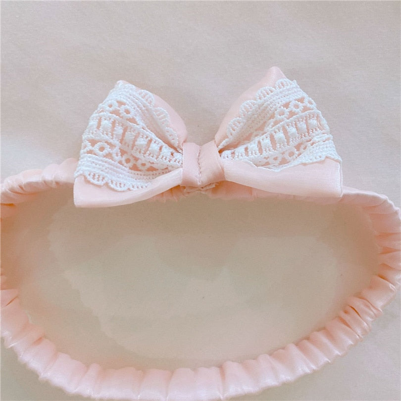 Pink elasticized baby headband with lace trim that comes with the Spanish Baby Clothing for reborn dolls.