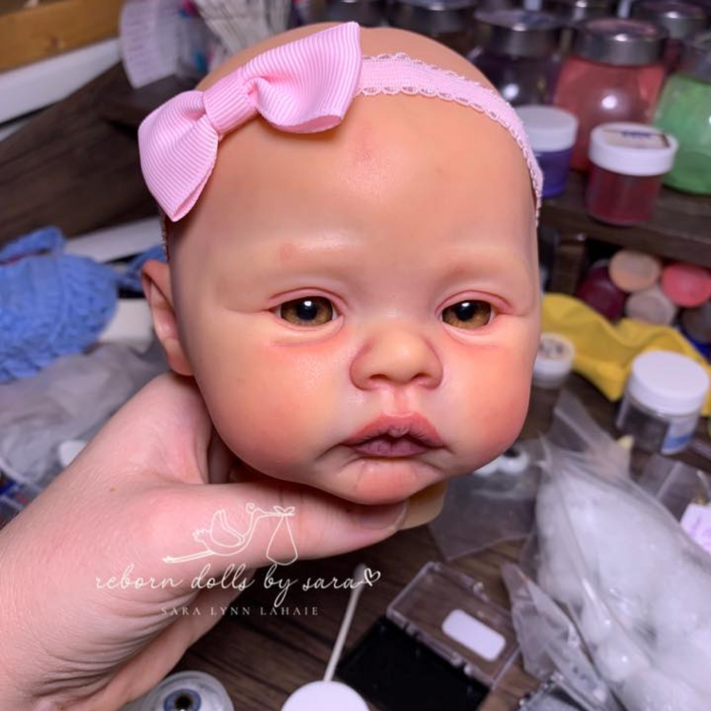 How to make a reborn art doll blog and list of tutorials. In the photo I am pictured rooting a reborn doll and using a magnifying glass.