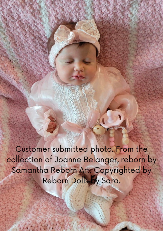 Reborn girl doll Lou Lou asleep by Joanna Kazmierczak wearing a pink Spanish vintage baby romper from Reborn Dolls by Sara.