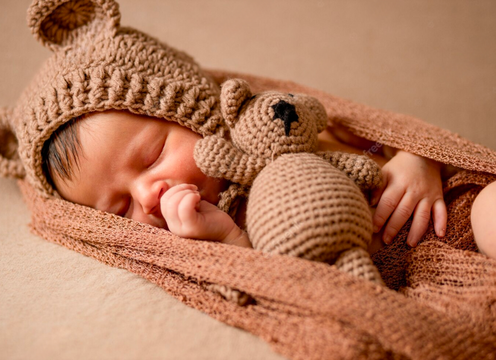 Newborn baby boy wearing the khaki tan Cutie Pie Crochet Newborn Baby Bear Bonnet with Matching Stuffy
