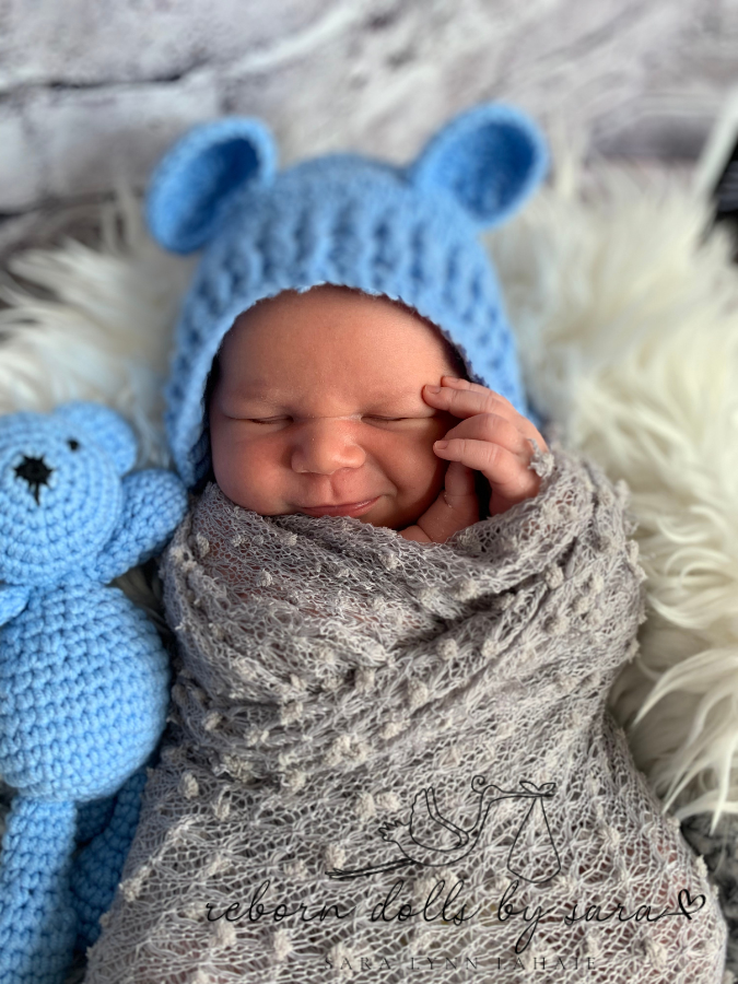 Newborn baby boy wearing the blue Cutie Pie Crochet Newborn Baby Bear Bonnet with Matching Stuffy