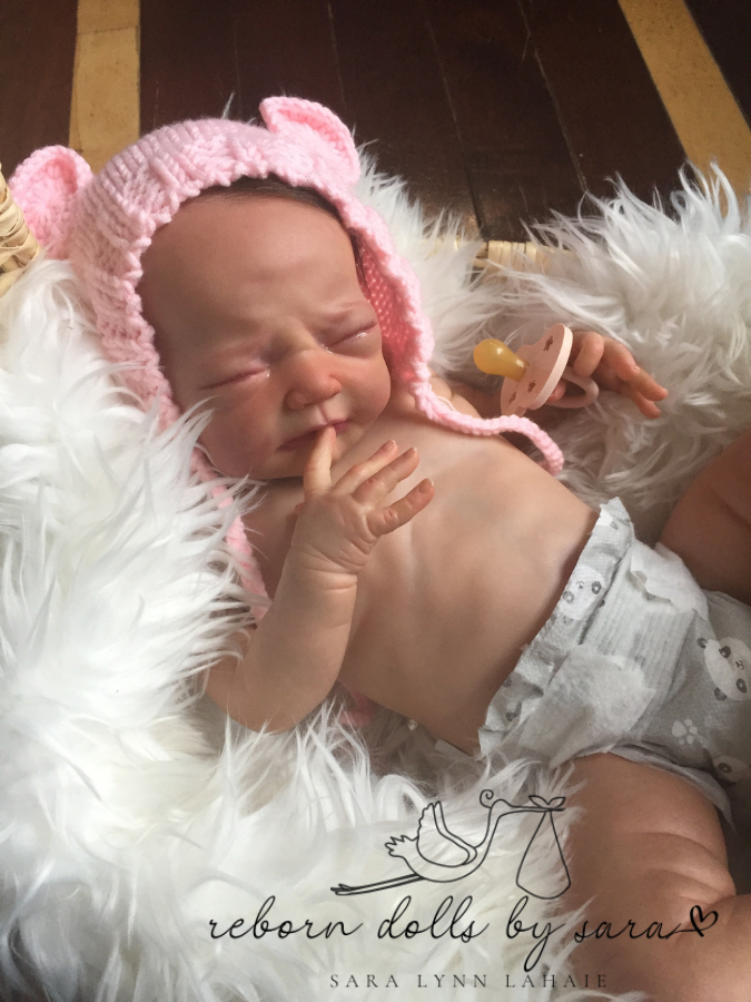 Sold out limited edition reborn baby girl doll Lucia by Adrie Stoete reborn by Reborn Dolls by Sara wearing the pink Lovey hand knitted newborn baby bear hat with matching teddy.