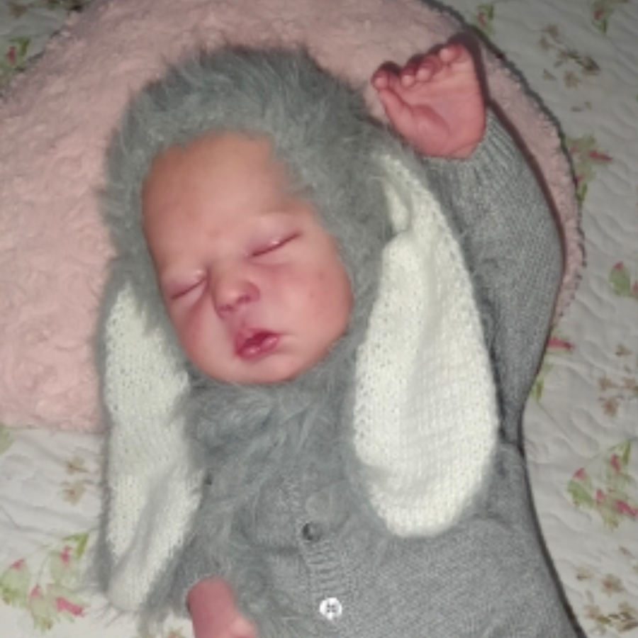 Reborn doll wearing the grey floppy eared fuzzy knitted mohair baby bunny bonnet for newborn photography and baby dolls.