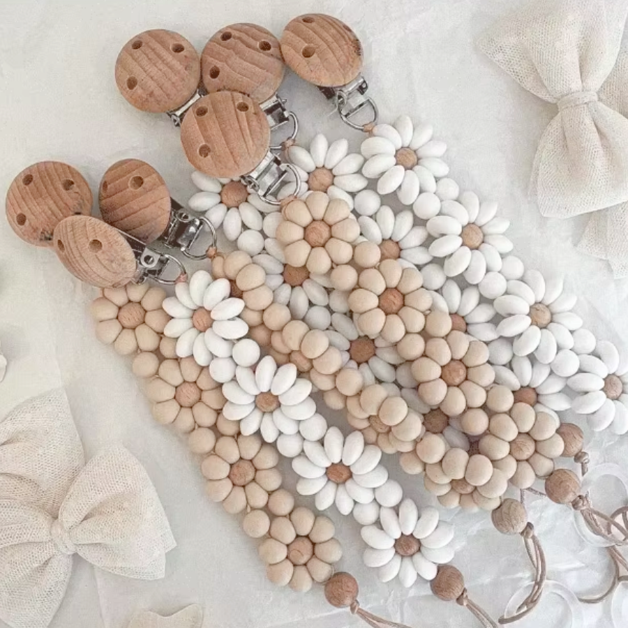 Tan and white Boho baby pacifier clip in the shape of a daisy flower. Made of silicone saucer beads on a wooden clip with wooden beads for reborn dolls.