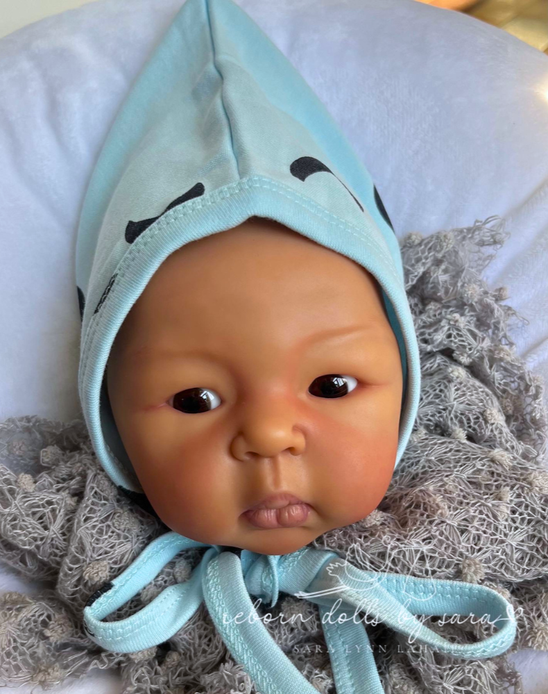 Light blue long-sleeve button-up romper with mustard yellow toe tips and black moon crescent designs. Comes with a matching pixie bonnet hat with a drawstring for babies and reborn dolls.