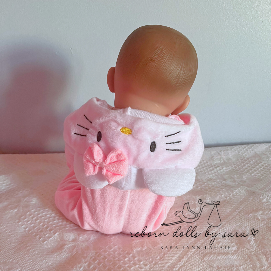 15" Berenguer reborn baby doll wearing a pink hello kitty romper outfit for mini and micro reborn dolls.