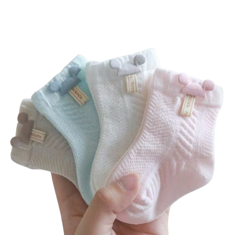 Hand holding four pairs of Mickey Mouse reborn doll, newborn baby, and cuddle baby cotton socks in beige, blue, whit and pink.