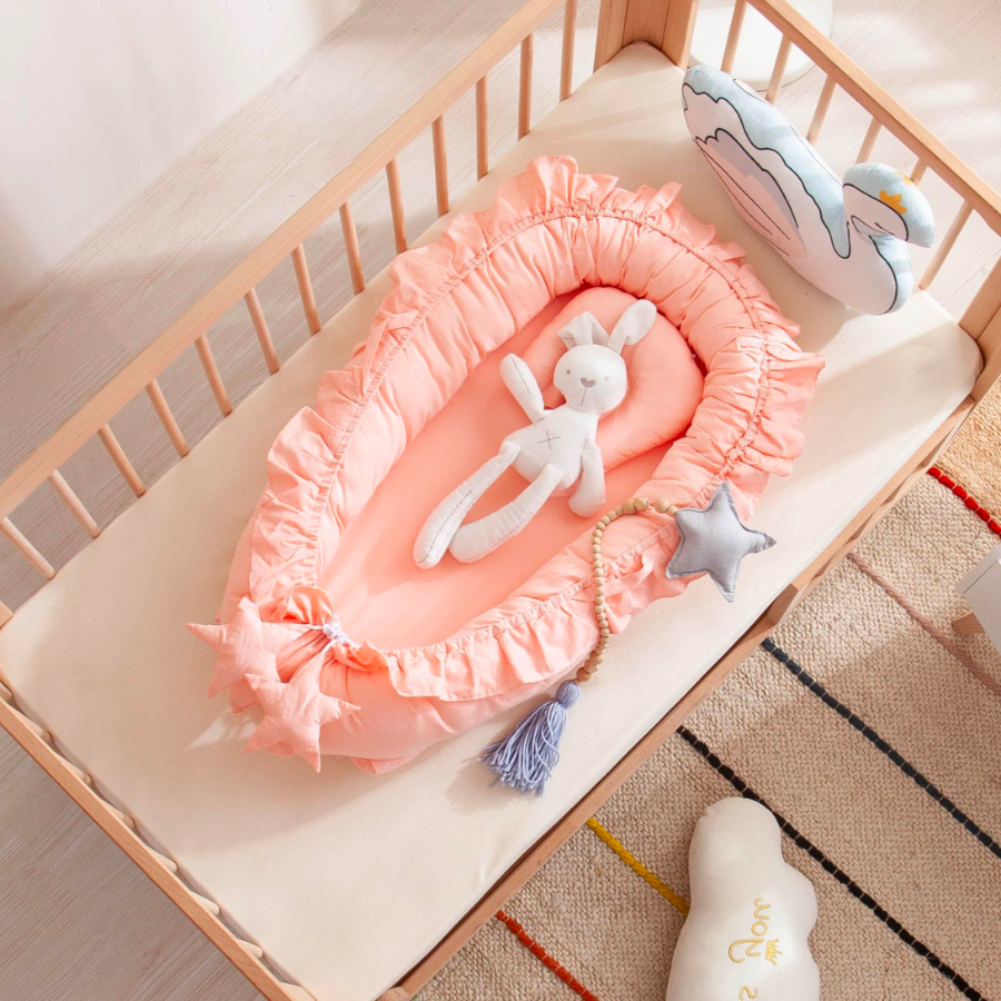 Pink shooting star boho baby nest with ruffles for newborn babies and reborn doll displays.