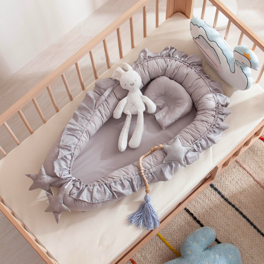 Grey shooting star boho baby nest with ruffles for newborn babies and reborn doll displays.