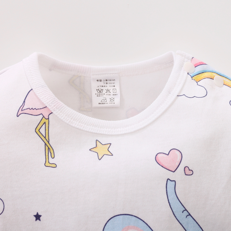 Close-up of neckline and tag on the white long-sleeve baby romper with blue elephants, rainbows, flamingos, stars and hearts on it for reborn baby dolls.