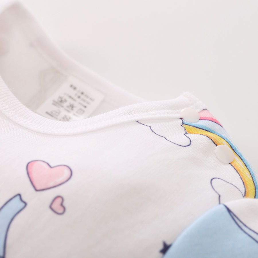 Close-up of the buttons on the shoulder of the white long-sleeve baby romper with blue elephants, rainbows, flamingos, stars and hearts on it for reborn baby dolls.