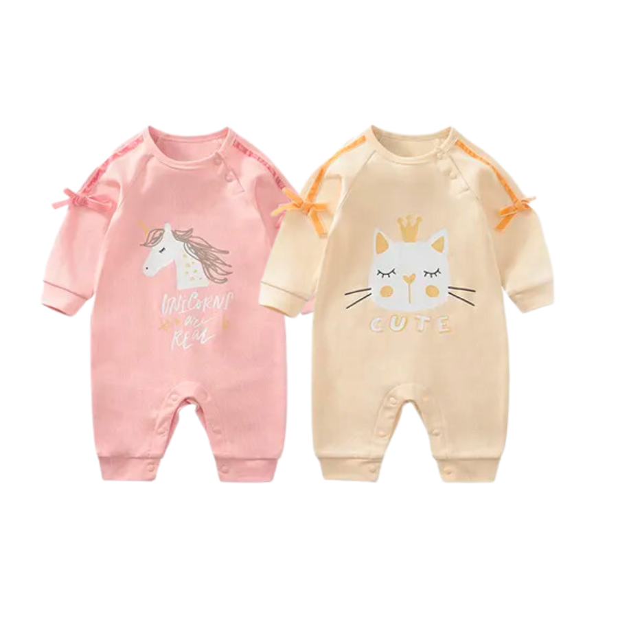 Two long-sleeve rompers for reborn dolls. One is pink and has a unicorn on it with the words saying "unicorns are real" and the other is yellow, and has a white cat on it with closed eyes that says "cute" underneath. Reborn doll clothes.