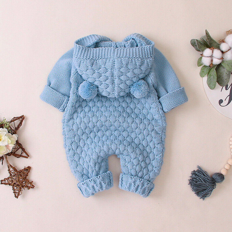 Backside of a blue knitted long-sleeve button-down teddy bear romper with hood and two pompom bear ears for reborn baby dolls.