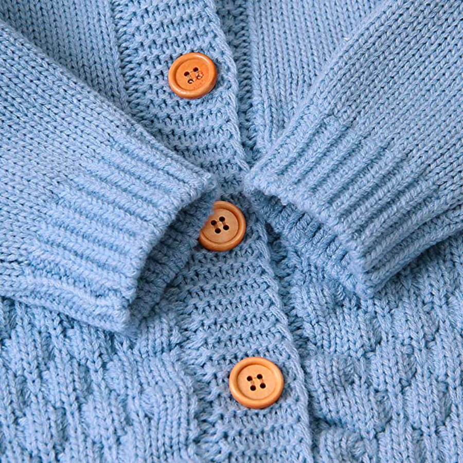 Close-up of the buttons and sleeve cuffs on a blue knitted bear romper for reborn dolls.