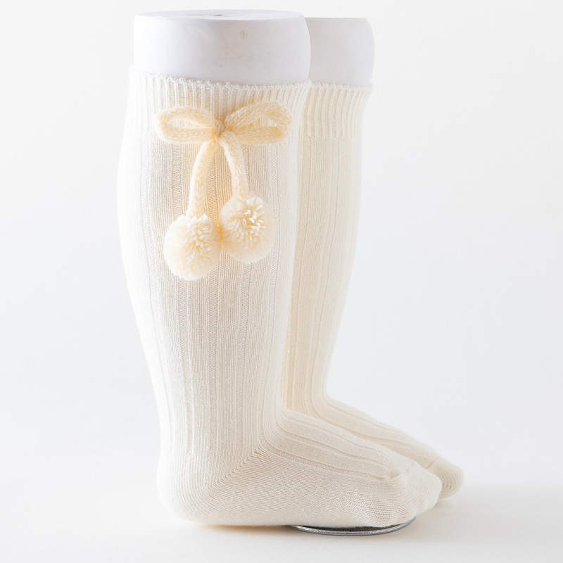Off-white cream vanilla knee-high Spanish baby socks with pompoms for reborn baby dolls boys and girls.