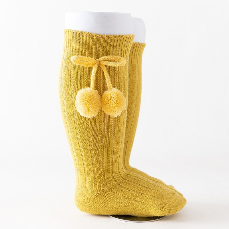 Mustard yellow knee-high Spanish baby socks with pompoms for reborn baby dolls boys and girls.