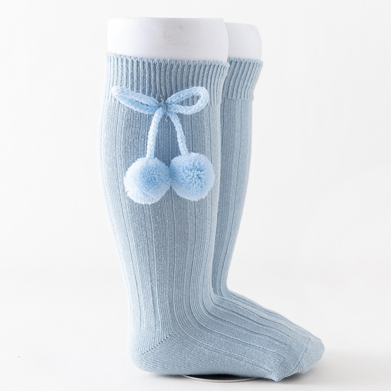 Light blue knee-high Spanish baby socks with pompoms for reborn baby dolls boys and girls.
