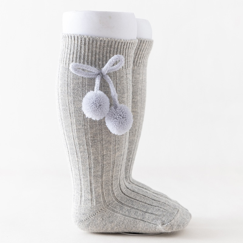 Light grey knee-high Spanish baby socks with pompoms for reborn baby dolls boys and girls.