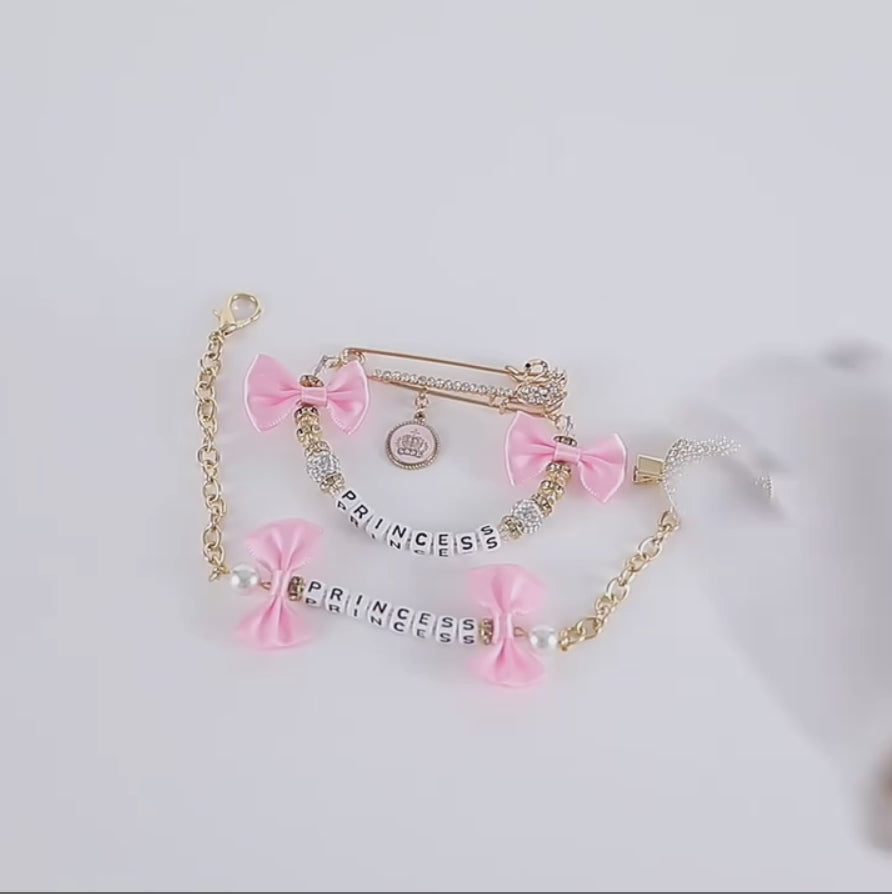 Video of baby pink bows, gold and pearl luxury bling rhinestone personalized pacifier clip and brooch set for reborn baby dolls and newborn babies.