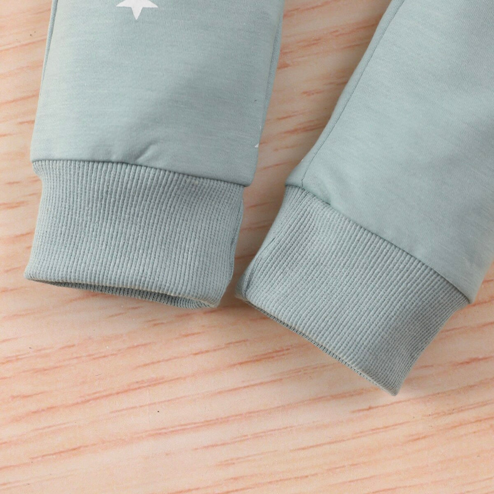 Close up of the legs on a Mint green jogging suit with white stars for newborn babies and reborn baby dolls.