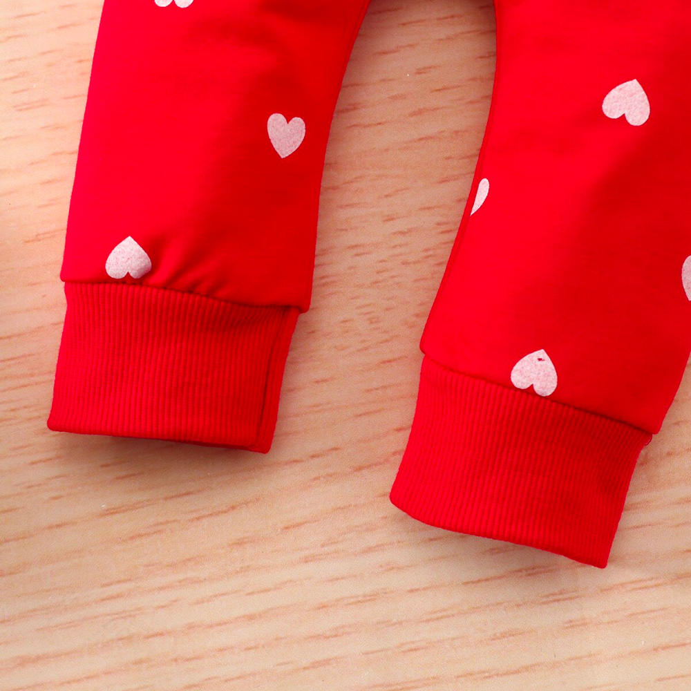Close up of the legs and ankles of a Red jogging suit with white hearts for newborn babies and reborn baby dolls.