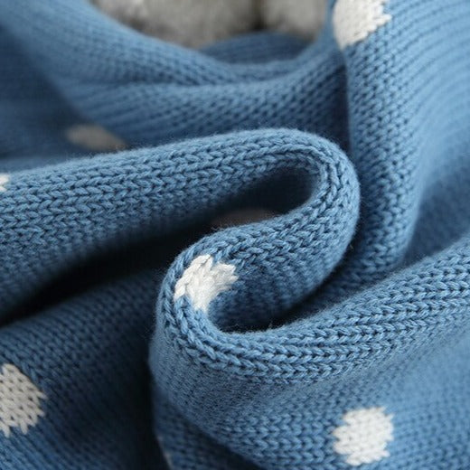 Close-up of knit material on Knit bubble rompers with white peter pan collars, a drawstring around the waist with two pompoms, and buttons at the crotch and back of neck. Reborn Doll Clothes and Baby Clothing.