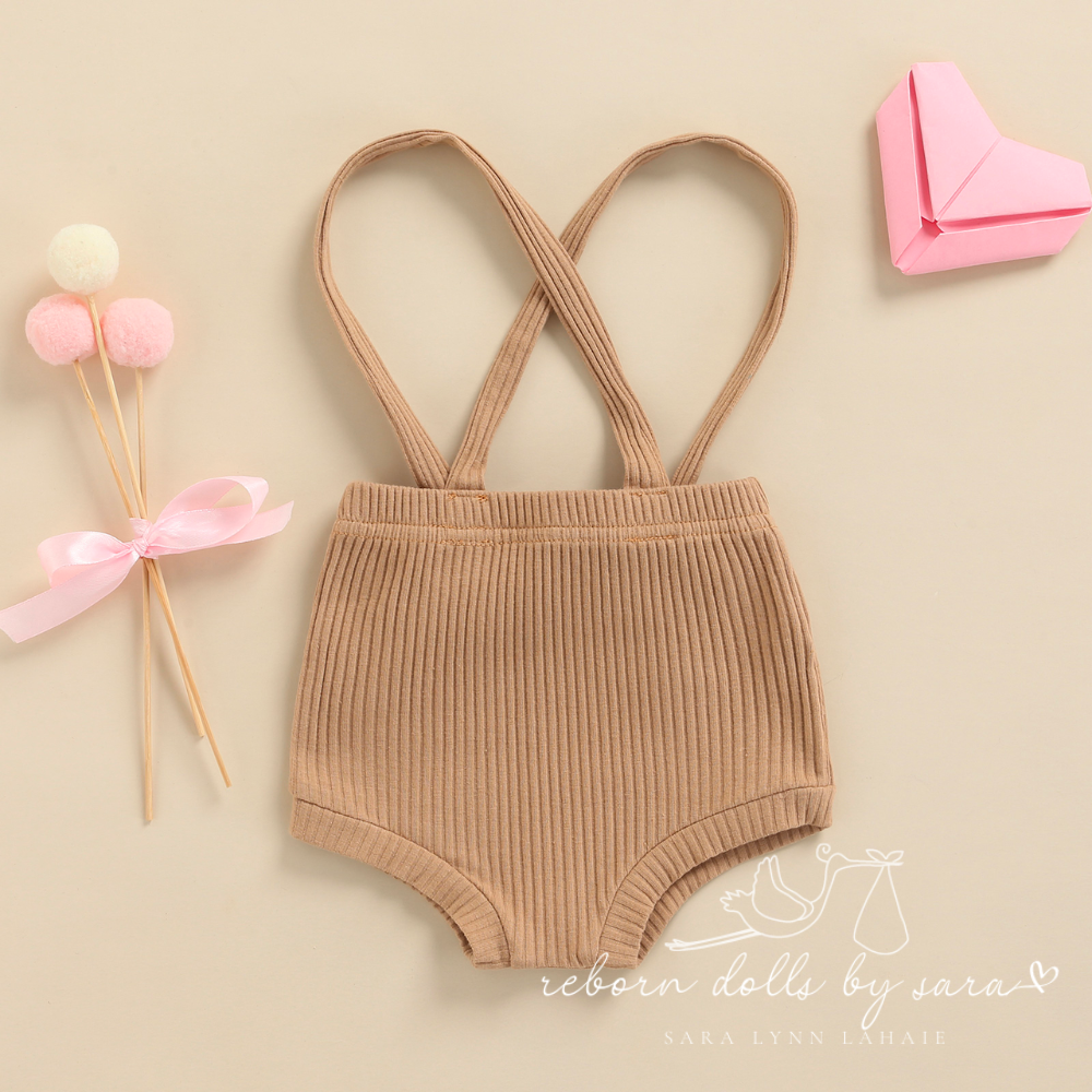 Back of a pair of khaki ribbed boho baby bloomers with suspenders for reborn baby dolls.