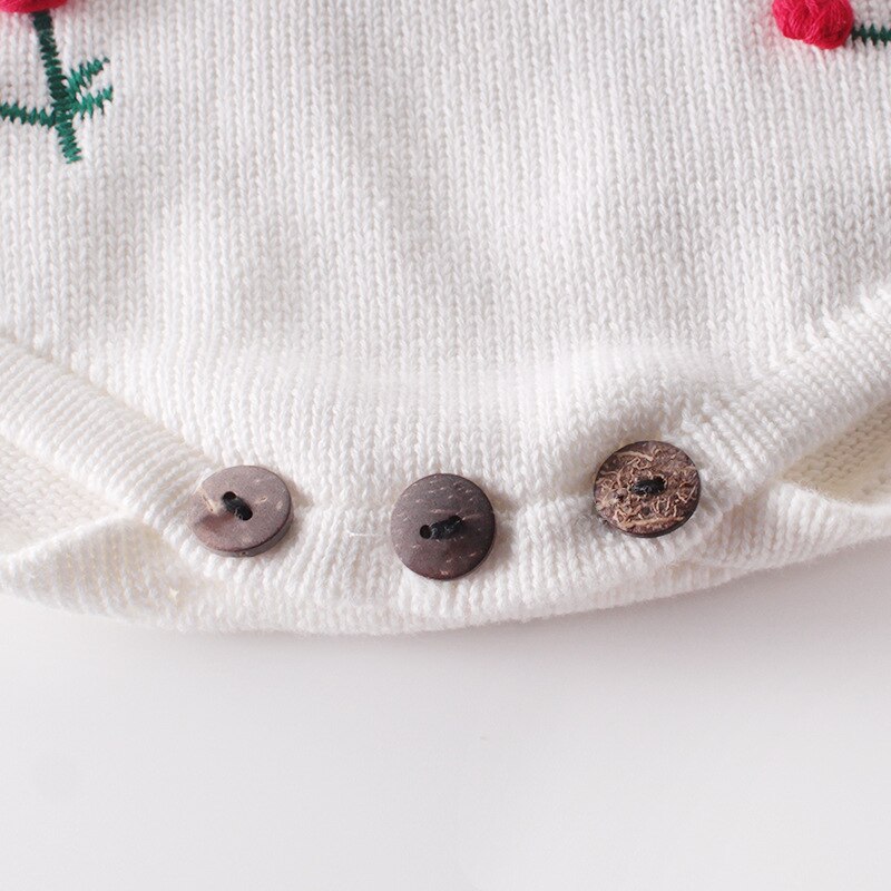 Close-up of the crotch on the White knitted 100% cotton long-sleeve onesie with red, 3D cherries on it for baby girls and reborn dolls