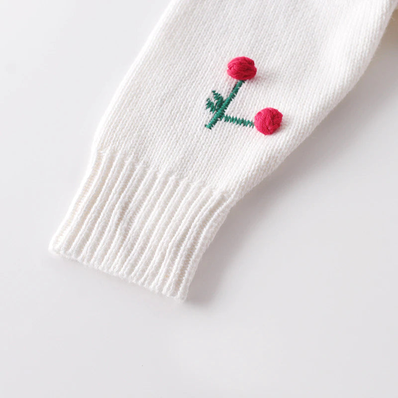 Closeup of the sleeve on the White knitted 100% cotton long-sleeve onesie with red, 3D cherries on it for baby girls and reborn dolls