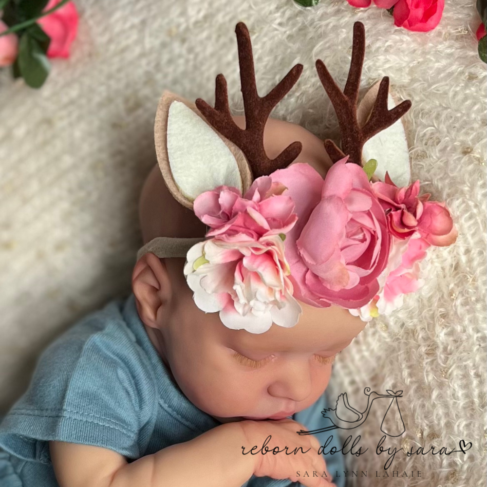 Baby deer antler headbands with faux flowers for reborn dolls and newborn baby photoshoots. Twin B wearing the Pink with Ears option by reborn dolls by sara.