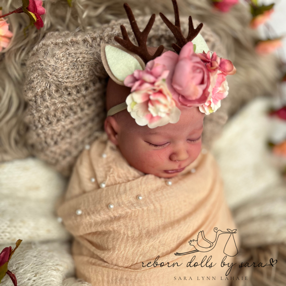 Baby deer antler headbands with faux flowers for reborn dolls and newborn baby photoshoots. Sage by Bountiful Baby cuddle baby by reborn dolls by sara wearing the pink with ears version.