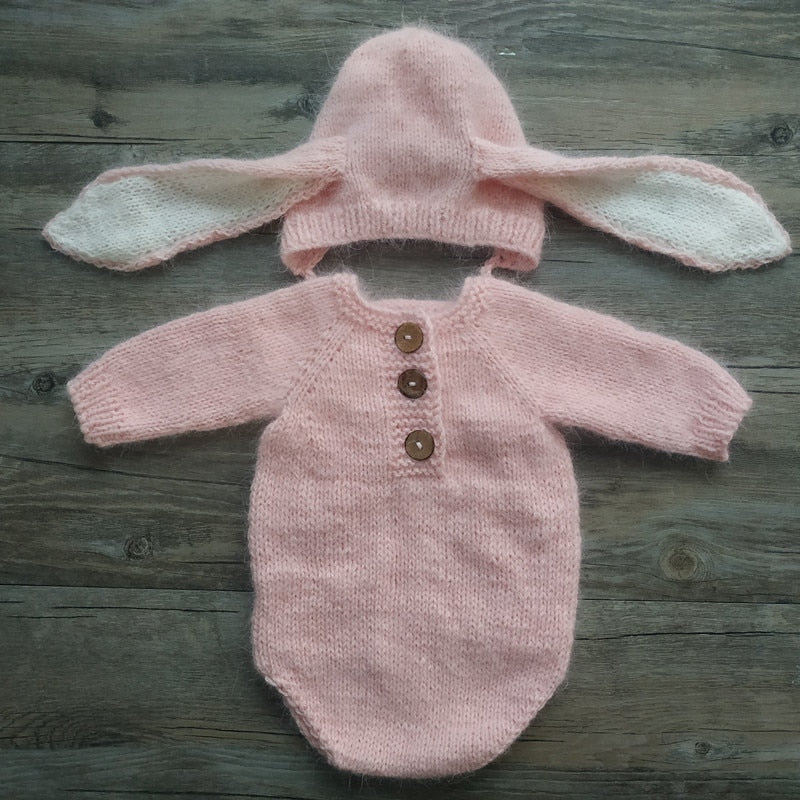 Pink knitted floppy eared bunny rabbit newborn photography hat and long-sleeve onesie bodysuit for reborn baby dolls.