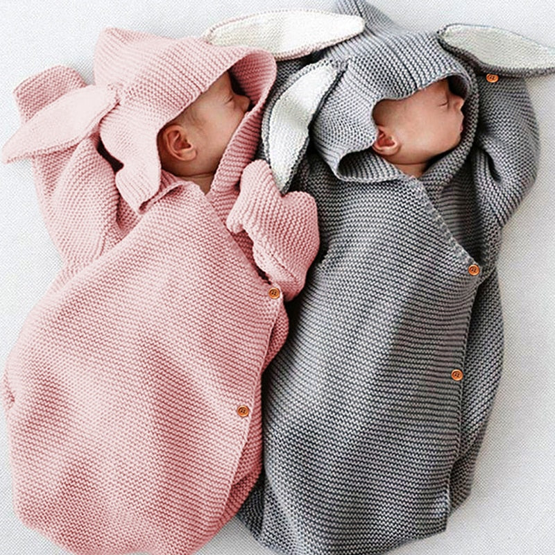 Two newborn babies in a pink and grey knitted newborn baby bunny rabbit sleep sacks sleeping bags for newborn babies and reborn dolls.
