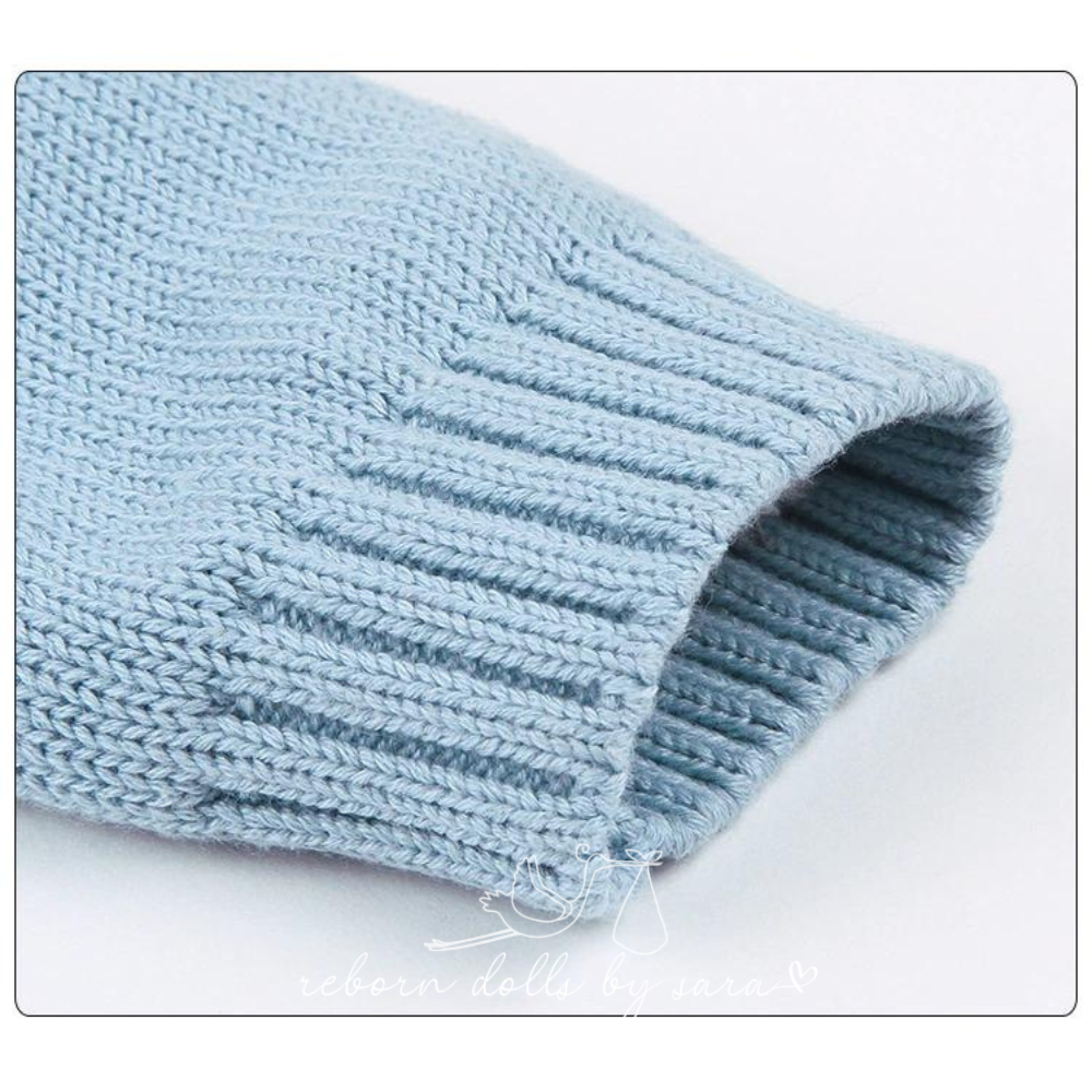 Close-up of the sleeve cuff on a blue knitted long-sleeve sweater onesie romper for reborn baby dolls.