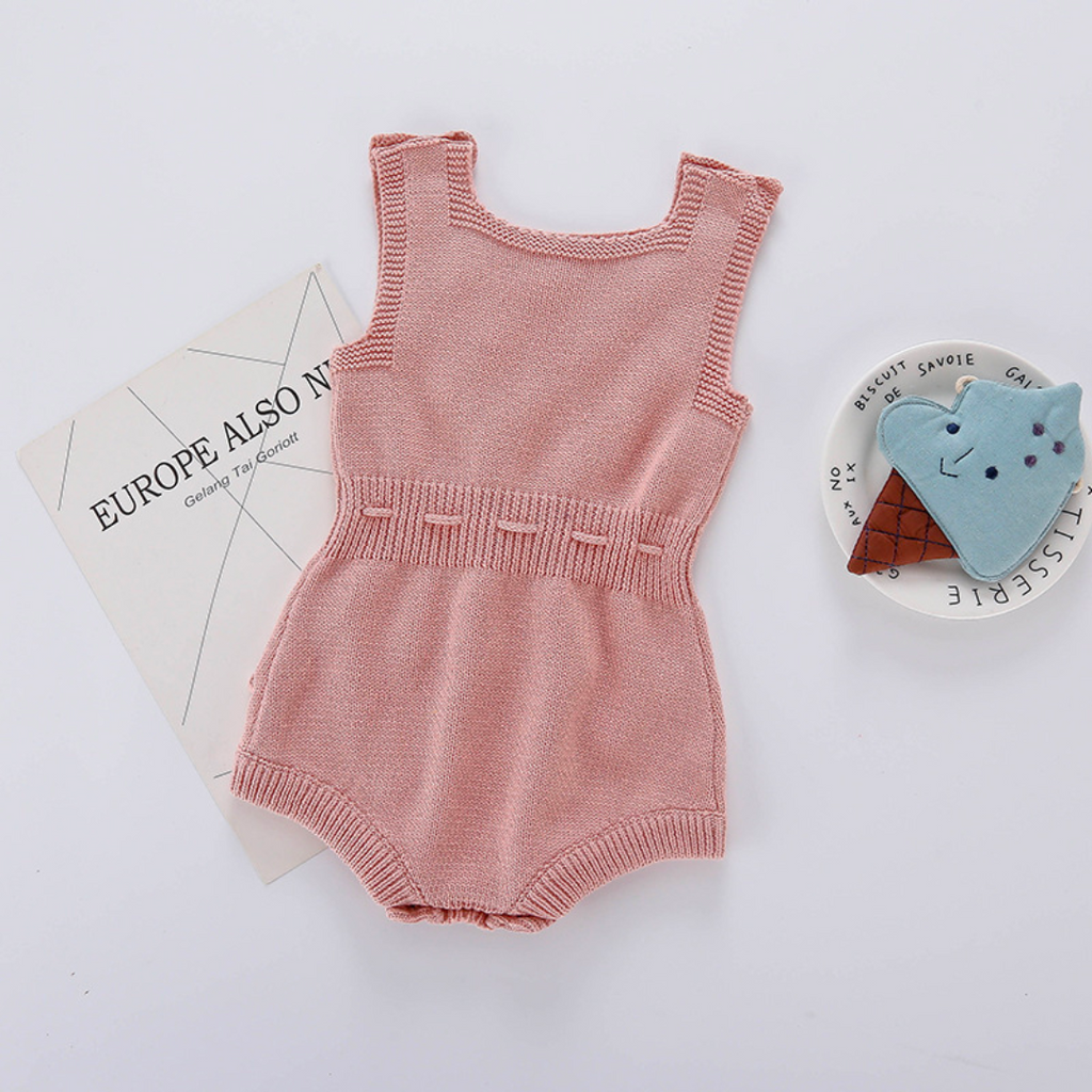 Back of Baby pink sleeveless knitted bubble romper with pink pompoms on the front, buttons on the shoulders, and buttons at the crotch. It also features a functional drawstring and is made to fit newborns baby girls to 2 year olds and reborn dolls.