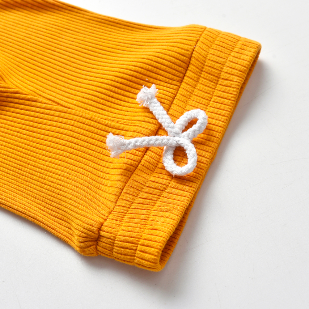 Close-up of the elastic waist and faux drawstring on a mustard yellow ribbed onesie and pant set called The Baby Oliver ribbed jogging suit for reborn baby boys and newborn babies.