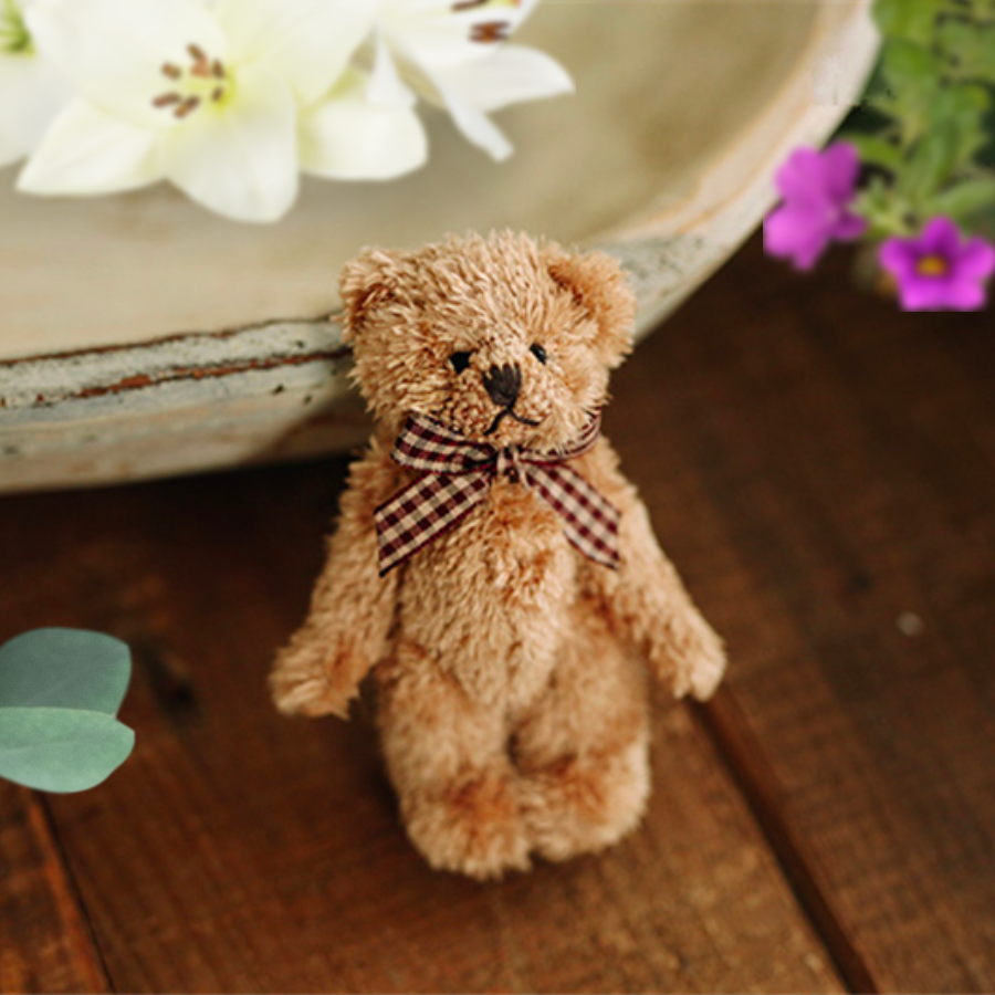 Brown teddy bear wearing a plaid bow. Reborn baby doll teddy bear toys that can be used by newborn photographers as well as newborn photography props.