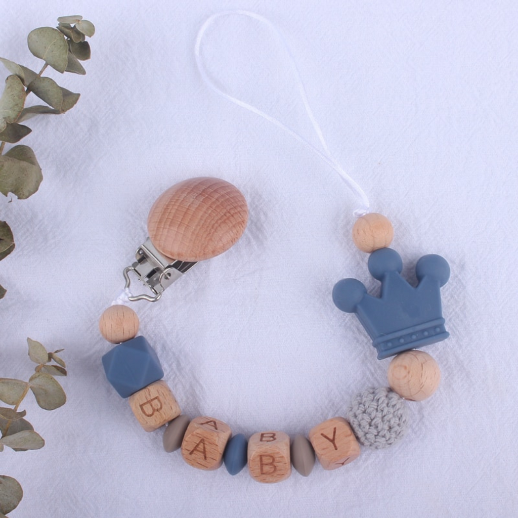 Ocean blue personalized silicone pacifier clips with wooden fastener, crown bead, crochet beads, wooden beads with spacers between them, and silicone beads with baby's name for reborn baby dolls.