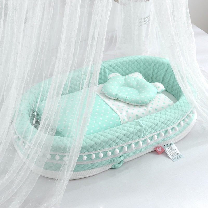 Turquoise baby nest lounger with pompoms and turquoise and white star blankets for reborn baby dolls.