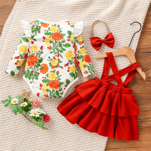 Back of a white long-sleeve onesie with white frills at the sleeve and orange and yellow floral pattern, with green leaves and red berries. Comes with a scarlet red waffle knit dress with straps that button on the inside of the dress and a matching nylon bow headband for reborn baby girls.