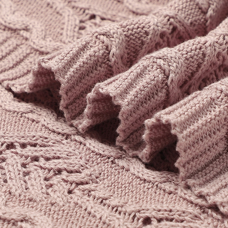 Close-up of the material and stitching on a blush pink coloured Fern Gully knitted baby blanket for reborn dolls and newborn babies.