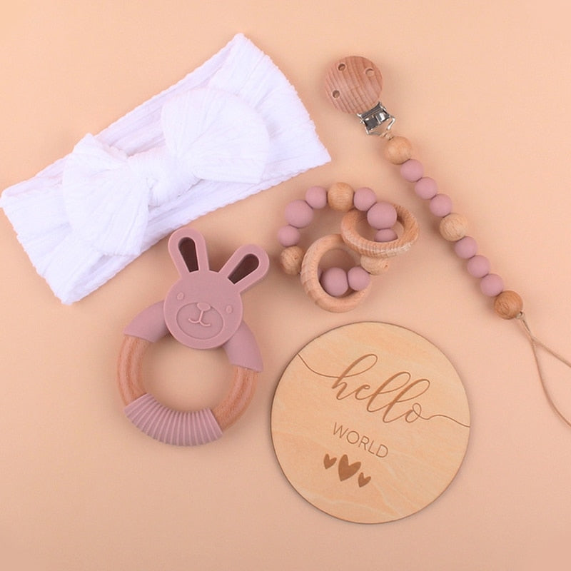 Tie-Dye Purple and dusty rose Five Piece Boho Baby Girl Gift Set and reborn doll box opening with teething ring, headband, milestone card that says hello world, silicone pacifier clip and silicone teething bracelet with wooden rings.