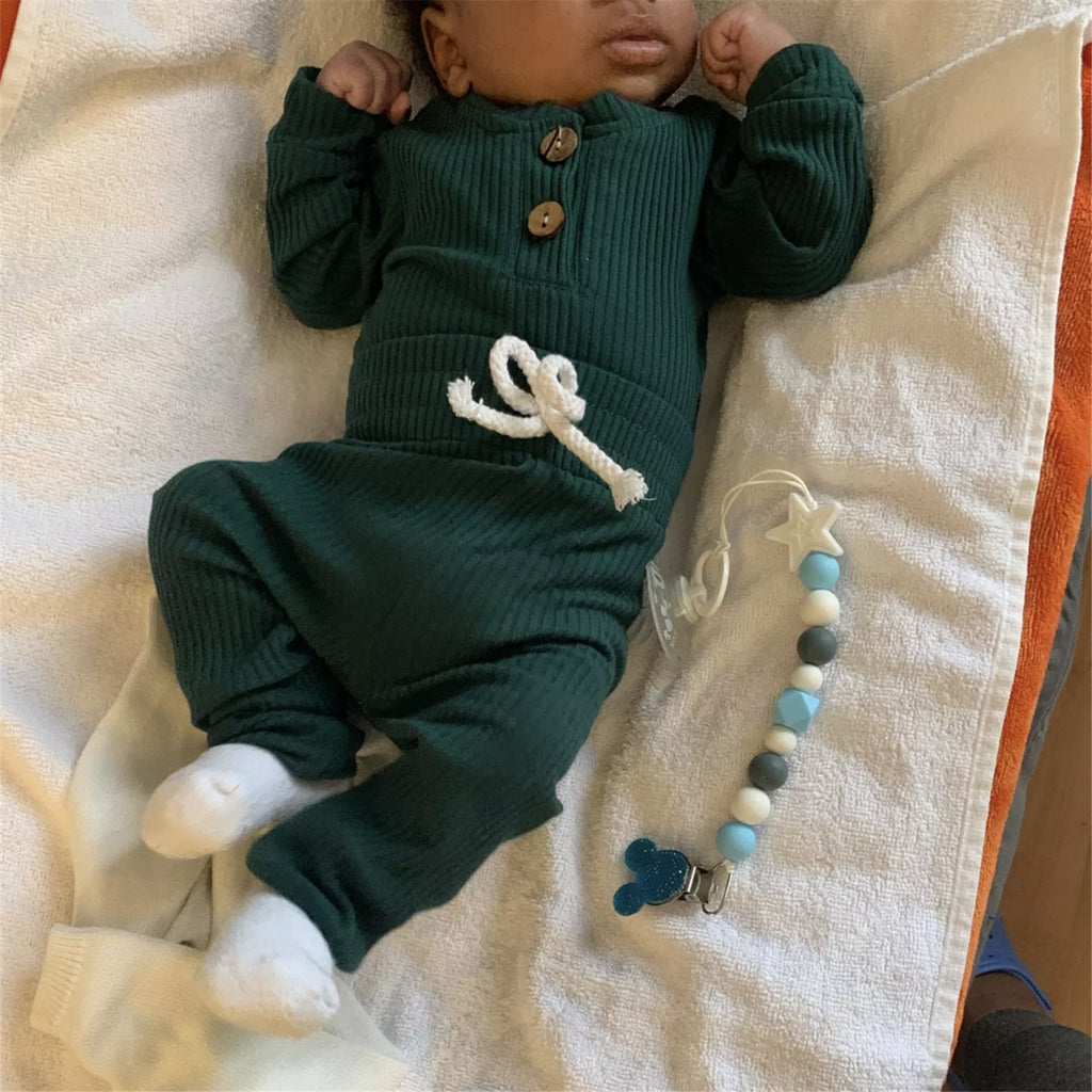 Black baby wearing a forest green ribbed onesie and pant set called The Baby Oliver ribbed jogging suit for reborn baby boys and newborn babies.