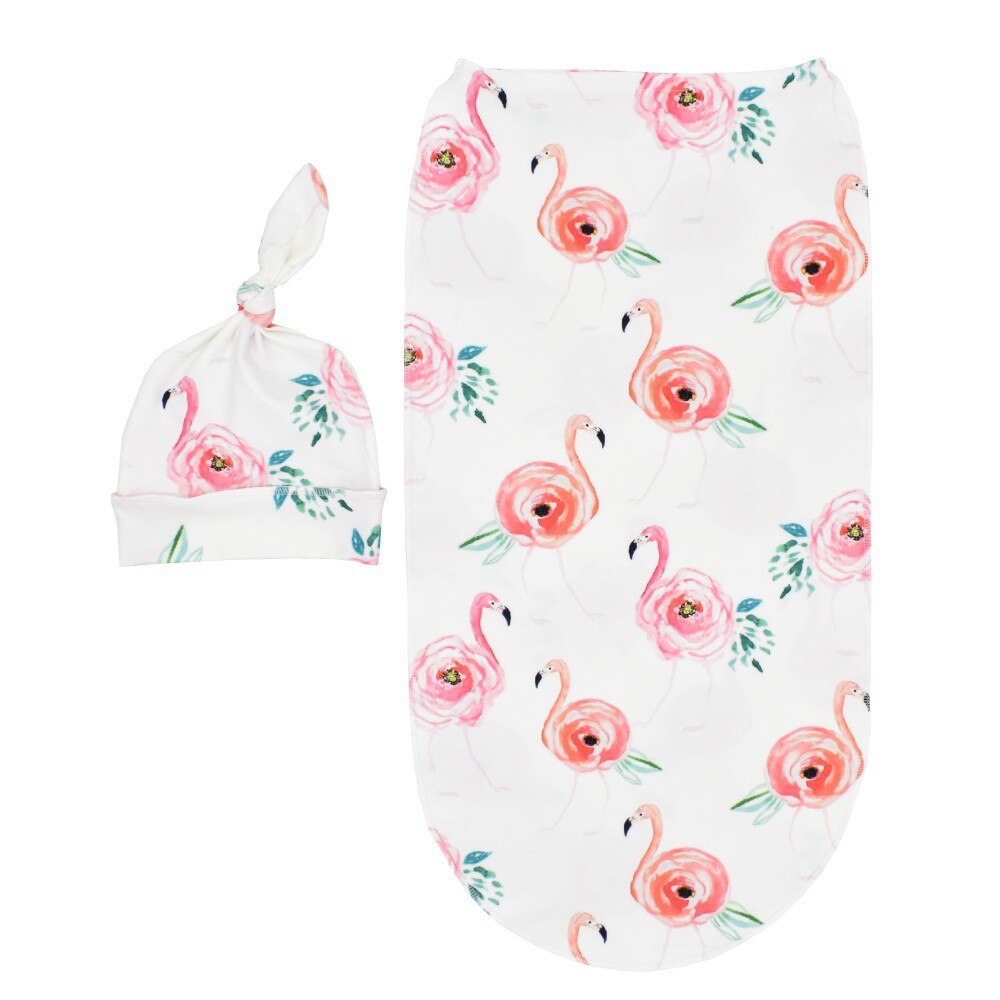 White newborn sleep sack cocoon with pink flamingos with rose bodies on it and a matching knotted baby hat for reborn dolls and cuddle babies.
