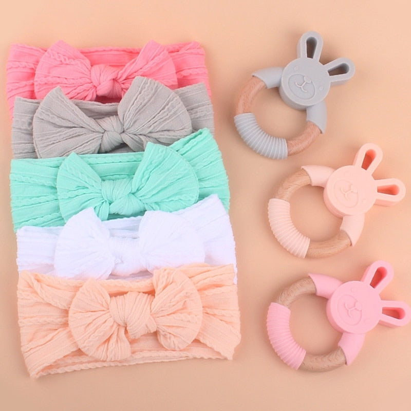Five Piece Boho Baby Girl Gift Set and reborn doll box opening with teething ring, headband, milestone card that says hello world, silicone pacifier clip and silicone teething bracelet with wooden rings.