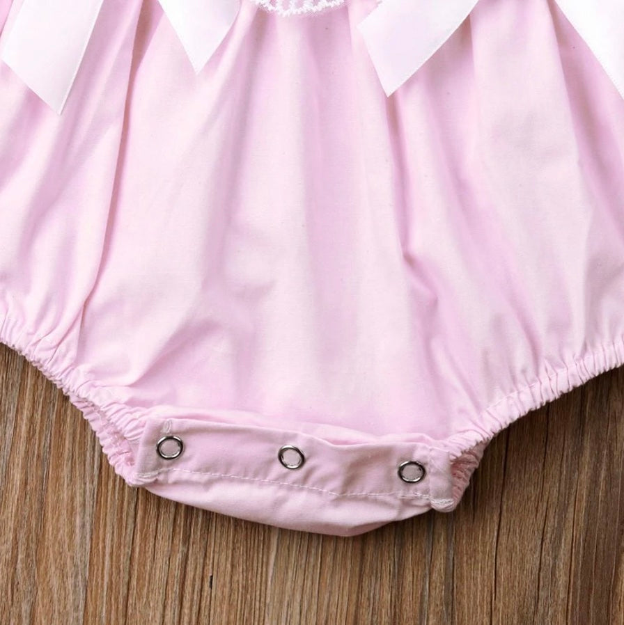 Close-up of snap buttons on crotch of pink Spanish baby clothing bubble romper for reborns and babies: reborn doll clothing