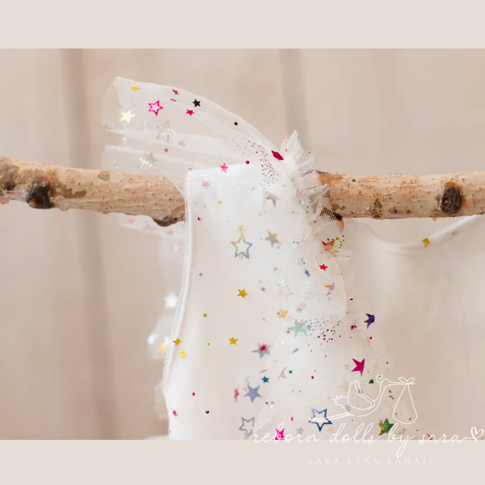White newborn photography tulle dress with hologram rainbow colored stars for reborn baby dolls.