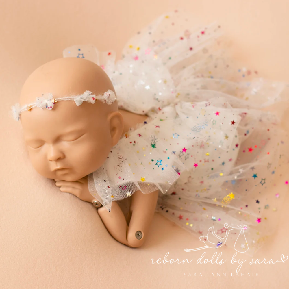 White newborn photography tulle dress with hologram rainbow colored stars for reborn baby dolls.