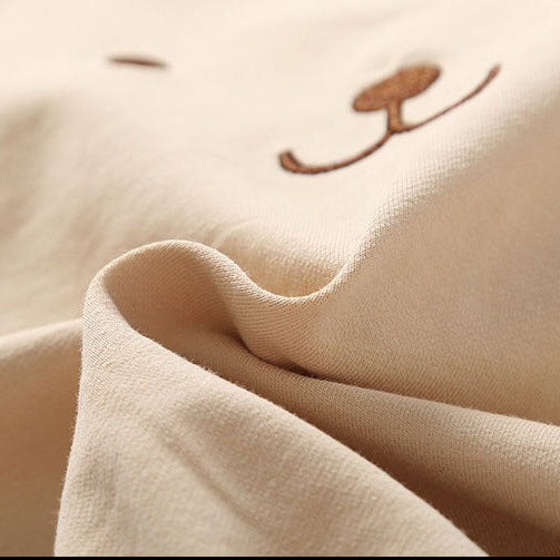 Close up of material texture on the beige light brown tan colored teddy bear overall bubble romper onesie for reborn baby dolls. Great clothing for twins!