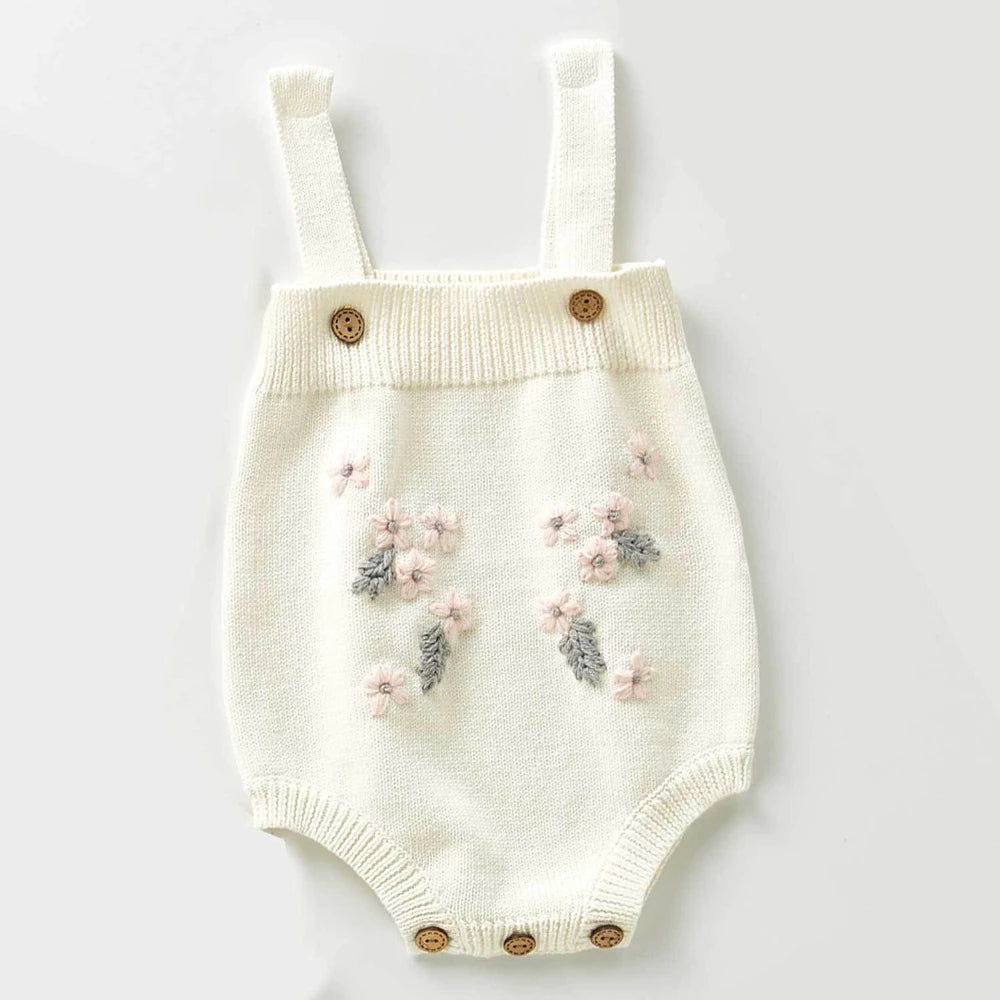 Creamy white knitted overall style onesie with buttons on the overall straps. Has beautiful pink and grey floral embroidery on the belly and buttons on the crotch. Made for newborn baby girls to 3 years old and reborn dolls.